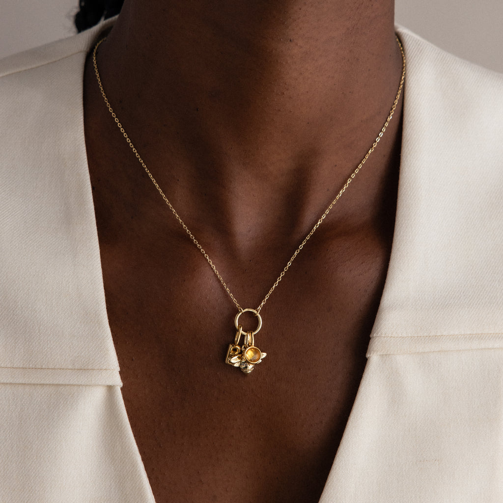 A modern essential, the Large Rolo Clasp Necklace features gold links and a bold chain detail—perfect for layering over a white blazer.