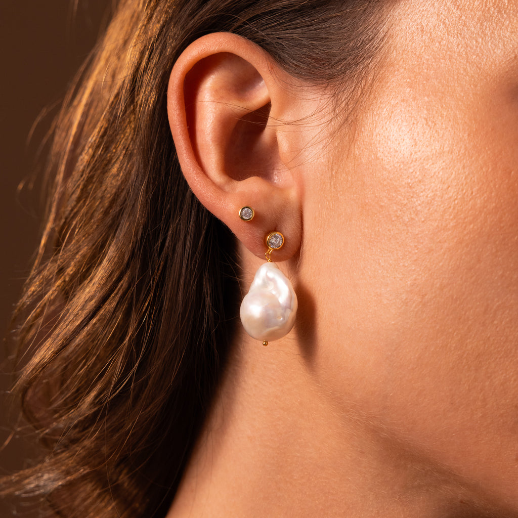Close-up of a woman's ear wearing Diamond Baroque Pearl Studs in 18K Gold, highlighting the elegance and unique beauty of organic pearl jewelry.