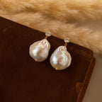 Diamond Baroque Pearl Studs in 18K Gold feature large baroque pearls and small diamonds, shown on brown velvet—a timeless piece of organic pearl jewelry.