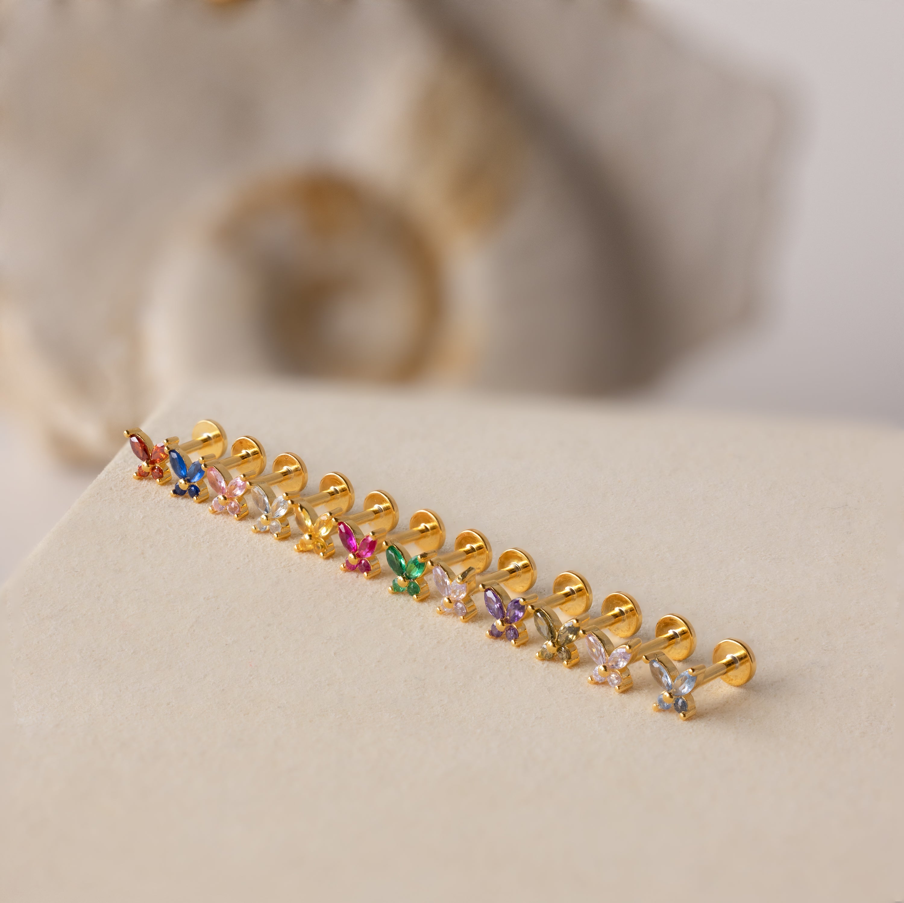 Butterfly Birthstone Flatback Studs featuring colorful gemstones are displayed on a beige surface—perfect for personalized jewelry lovers.