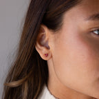 Close-up of a womans ear wearing Butterfly Garnet Flatback Studs—a small, elegant earring perfect for lovers of personalized jewelry.