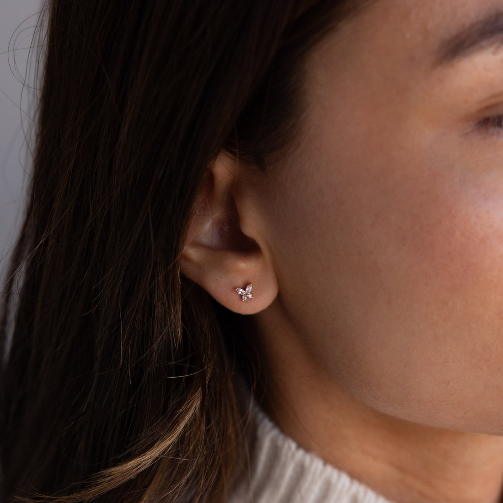 Close-up of a womans ear wearing Butterfly Alexandrite Flatback Studs, delicate butterfly-shaped earrings ideal for personalized jewelry lovers.
