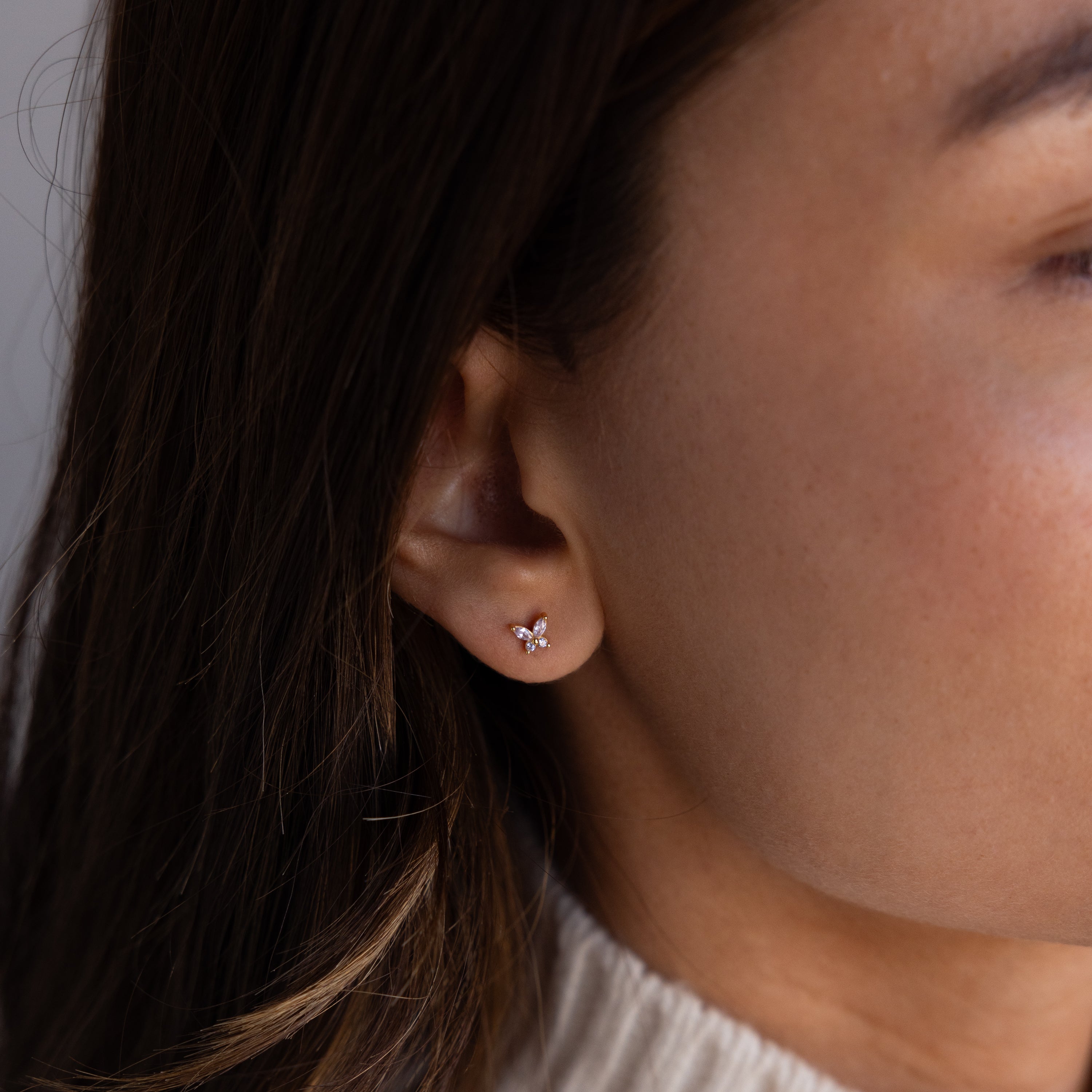 Close-up of a womans ear wearing Butterfly Alexandrite Flatback Studs, delicate butterfly-shaped earrings ideal for personalized jewelry lovers.