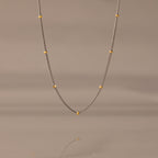 The Mixed Metal Beaded Necklace features a silver satellite chain with small gold beads evenly spaced—ideal for layering.