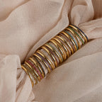 A striking full set of birthstone rings in gold finish, showcasing stones in every month’s color from garnet to zircon, wrapped over soft champagne-colored fabric.