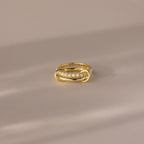 The Duo Birthstone Tennis Linked Ring Set in Opal (October) showcases minimalist linked rings with opal stones, beautifully arranged in a row and displayed on a light beige surface.