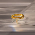 Linked Initial Topaz Ring Set featuring a textured gold band and a sparkling pavé "K" charm, elegantly displayed on glass.
