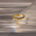 Linked Initial Birthstone Ring Set in Amethyst (February), featuring purple stones and a dangling letter D charm, displayed on a reflective surface.