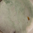 A close-up of the Green Marble Jewelry Dish, featuring a smooth pale green and white surface with subtle brown and yellow patches, perfect as a stylish jewelry holder.