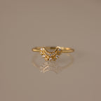 The Diamond Crescent Moon Ring features small sparkling stones and is displayed on a reflective surface—a celestial accessory perfect for adding shimmer to any look.