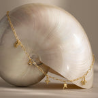 The Seaside Charm Necklace with sea-themed pendants drapes elegantly, adding beachy jewelry vibes to your seaside look.