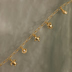 Seaside Charm Bracelet in 18K Gold: Features ocean-inspired turtle, shell, fish, and seahorse charms—ideal for coastal jewelry lovers. Shown on a gray background.