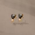 Abalone Pearl Heart Studs in 18K Gold feature heart-shaped abalone, gold accents, and dangling pearls—an elegant piece of coastal jewelry, beautifully displayed on a neutral background.