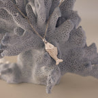 Fish Pendant Necklace shown on a textured light blue coral background—an elegant, ocean-inspired accessory ideal for everyday wear or as a unique layering piece.