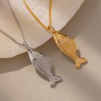 The Fish Pendant Necklace features two fish-shaped pendants—one silver, one gold—creating an ocean-inspired accessory perfect for layering, shown on a soft, neutral background.