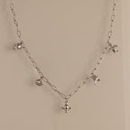 The Seaside Charm Necklace in Silver features five ocean-themed charms—crab, pufferfish, turtle, dolphin, and stingray—making it perfect beach jewelry for your summer necklace collection.