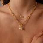 Close-up of a person wearing two necklaces: one with the Diamond Turtle Charm in Silver and the other featuring star and pearl pendants.