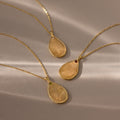 Three Fingerprint Birthstone Teardrop Necklaces in 18K Gold with custom fingerprint designs and gemstones are displayed on a beige background—each one a unique keepsake, ideal for those who love personalized jewelry.