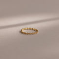 The Dainty Marquise Pink Tourmaline Ring, featuring a delicate gold design and marquise pattern, is showcased on a soft neutral background under gentle lighting.