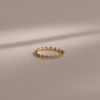 The Dainty Marquise Pink Tourmaline Ring, featuring a delicate gold design and marquise pattern, is showcased on a soft neutral background under gentle lighting.