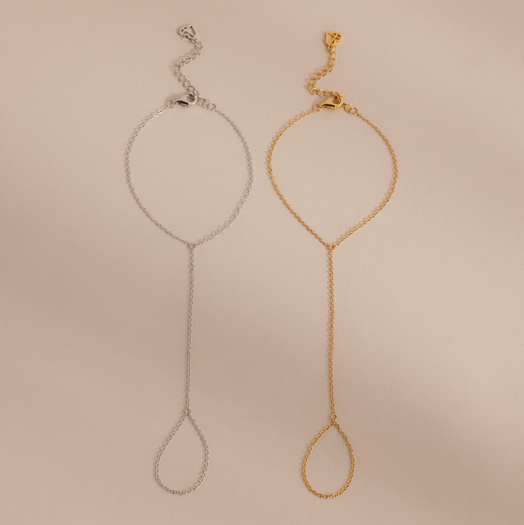 Two Dainty Hand Chain Bracelets, one in silver and one in gold, are displayed side by side on a beige background—perfect for anyone who loves delicate jewelry.