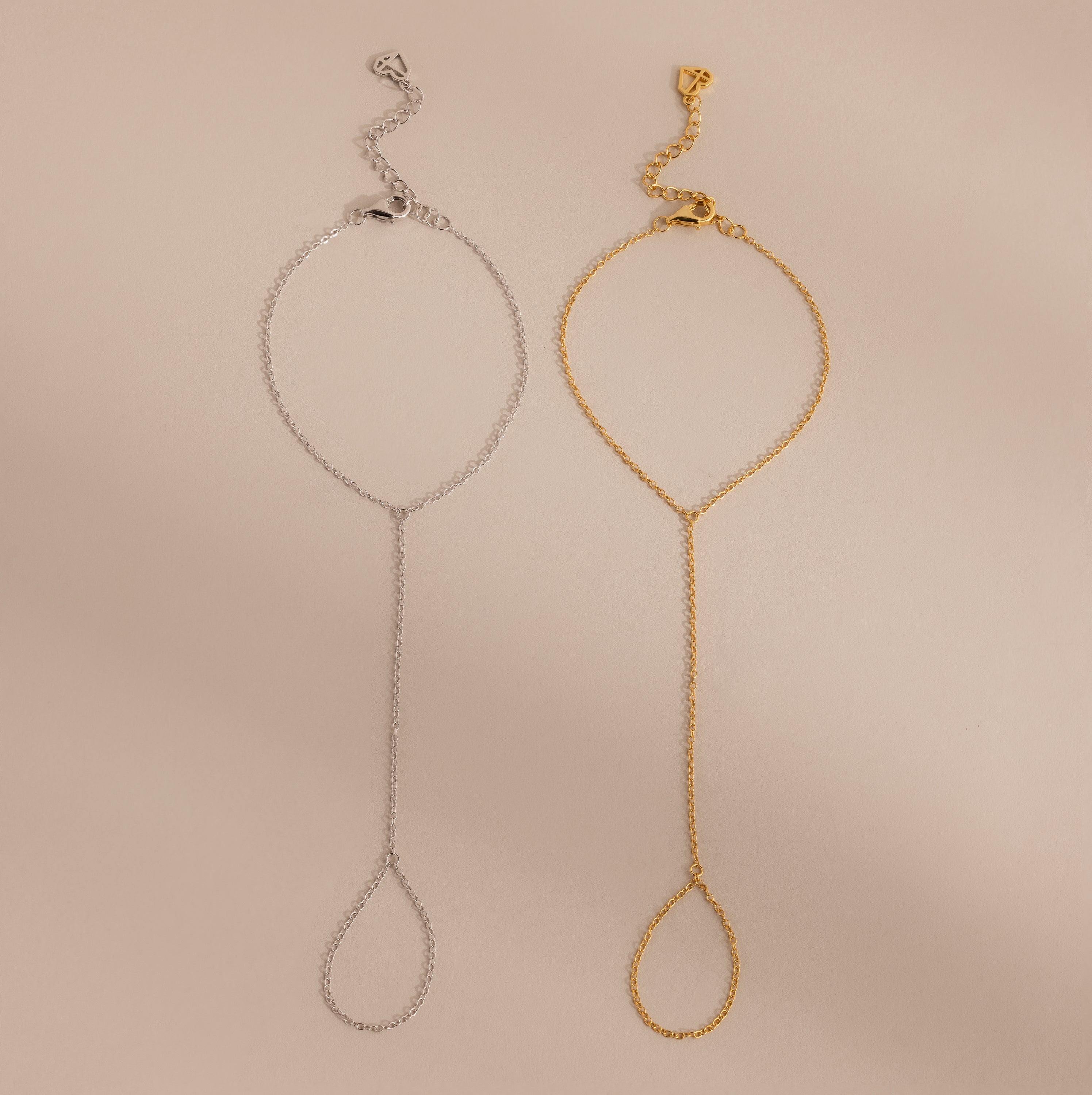 Two Dainty Hand Chain Bracelets, one in silver and one in gold, are displayed side by side on a beige background—perfect for anyone who loves delicate jewelry.