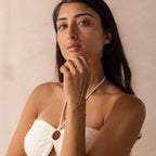 Model wearing a sterling silver hand chain bracelet that connects to a delicate finger loop.