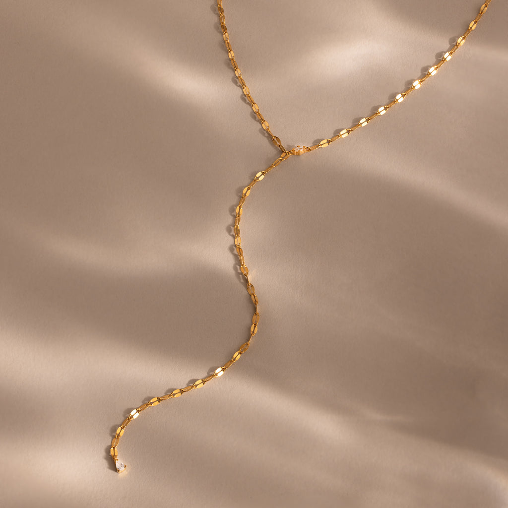 Gold dainty Sparkling Diamond Lariat Necklace with a delicate mirror chain design and two CZ diamond stones, displayed on a neutral surface.