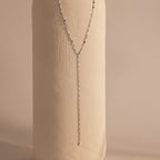 Silver dainty Sparkling Diamond Lariat Necklace with a delicate mirror chain design and two CZ diamond stones, displayed against a ceramic prop.