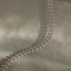 The Fishtail Chain Bracelet in Silver features interwoven links and a delicate leaf pattern, elegantly displayed on soft pale green fabric—an ideal gift for any occasion.