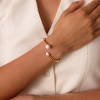Wearing the Serenity Pearl Cuff Bracelet in 18K Gold with two white pearls, paired with a cream top—this modern piece adds elegance to any look.
