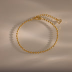 Dune Beaded Bracelet in 18K Gold features polished beads, an adjustable chain, and a heart charm, displayed on a neutral background.