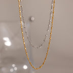 The Dot Station Necklace, available in silver and gold, is displayed against a neutral background—perfect for layering or wearing alone as a minimalist accessory.
