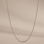 The Woven Chain Necklace is showcased against a neutral beige background.