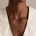 A person wearing the Woven Chain Necklace in 18K Gold paired with a cream-colored blazer.