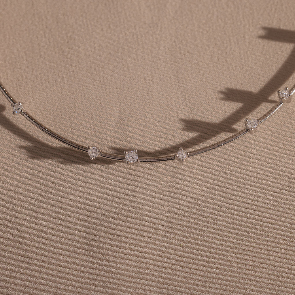 The Sprinkle Diamond Necklace in Silver features spaced diamond-like stones on a delicate silver chain, perfect for layering.