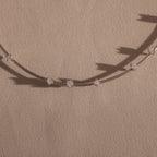 The Sprinkle Diamond Necklace in Silver features spaced diamond-like stones on a delicate silver chain, perfect for layering.