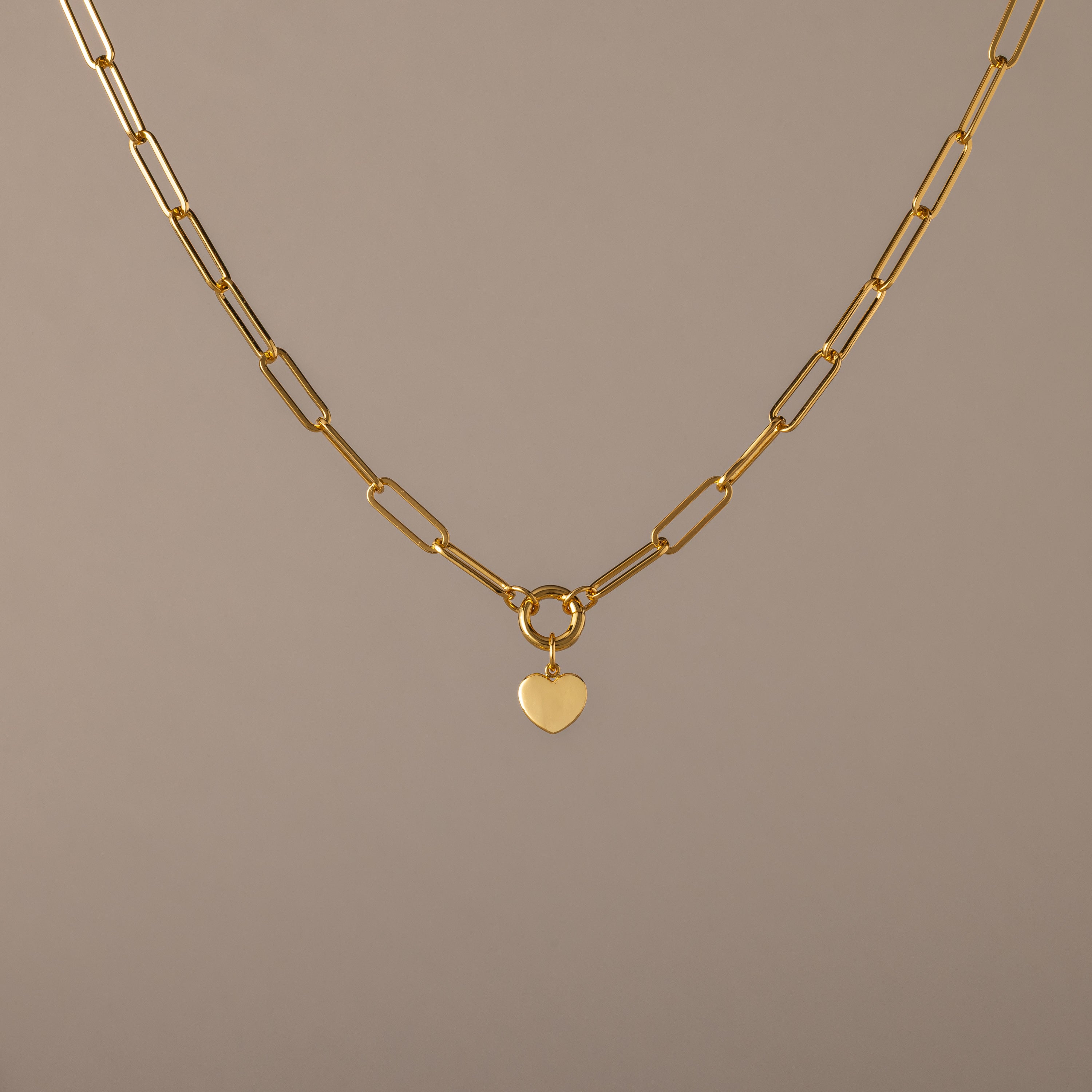 Paperclip Heart Charm Necklace in 18K Gold with elongated links and a delicate heart pendant, displayed on a neutral background—the perfect accessory for subtle elegance with any outfit.