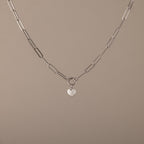 The Paperclip Heart Charm Necklace in Silver features elongated links and a small heart-shaped pendant—a delicate accessory perfect for everyday wear.