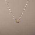 Pearl Chain Clasp Necklace in 18K Gold, featuring a gold circular pendant and shown on a beige background—a timeless piece for any jewelry collection.