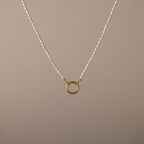 Pearl Chain Clasp Necklace in 18K Gold, featuring a gold circular pendant and shown on a beige background—a timeless piece for any jewelry collection.
