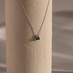 Flatlay of our Emerald Bloom Necklace with Pink Tourmaline and Emerald gemstones.