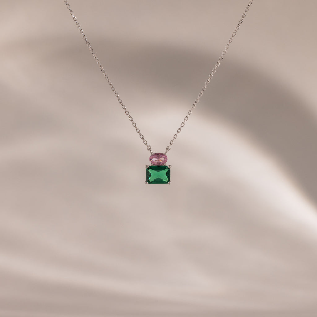 Flatlay of our Emerald Bloom Necklace with Pink Tourmaline and Emerald gemstones.
