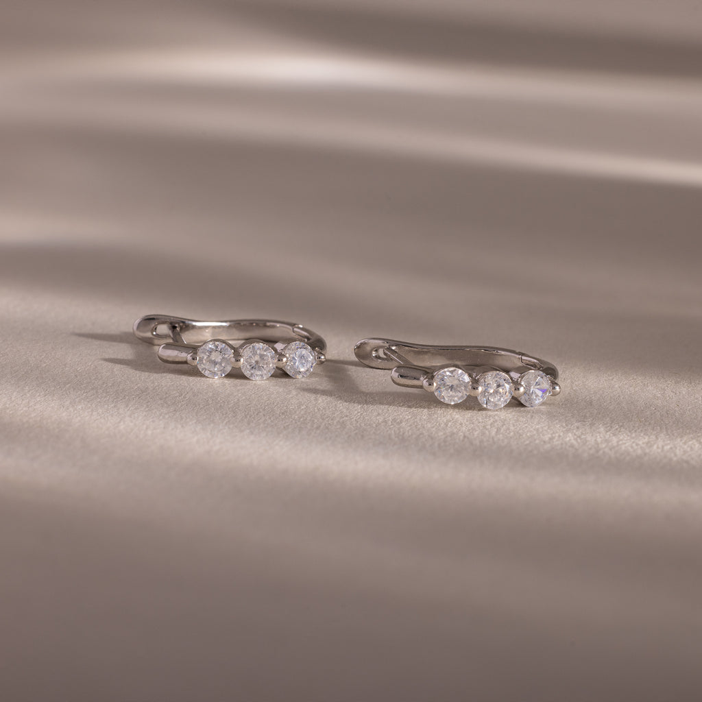Flatlay of our Lace Diamond Hoops in Sterling Silver on a beige fabric background
