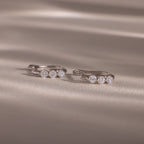 Flatlay of our Lace Diamond Hoops in Sterling Silver on a beige fabric background