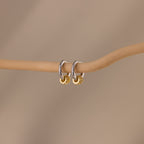 Image of our Mixed Metal Pave Hoops in White Gold hanging on a wooden stick