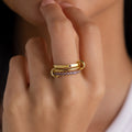 A hand with two gold rings, including the Triple Linked Blue Zircon Ring Set featuring sparkling blue zircon stones, near the person's lips.