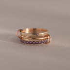 Triple Linked Alexandrite Ring Set featuring gold bands and small purple alexandrite gemstones, stacked on a neutral background.