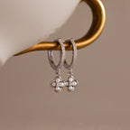 The Pave Rounded Pearl Flower Hoops in Sterling Silver feature elegant hoops with pave details and flower accents, making them an exquisite choice for wedding jewelry.