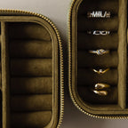 The Green Velvet Jewelry Box offers elegant storage, keeping gold and silver rings neatly organized in separate compartments.